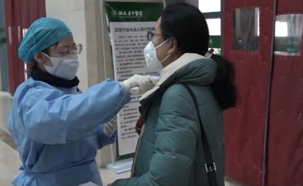 Large a nurse measuring the body temperature for outpatients in hubei tcm hospital